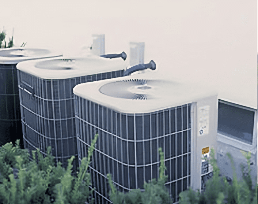 Three air conditioning units outside building.