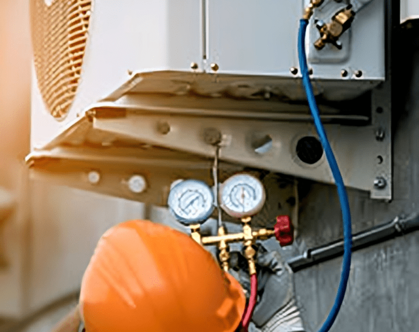 Technician checking air conditioning unit pressure.